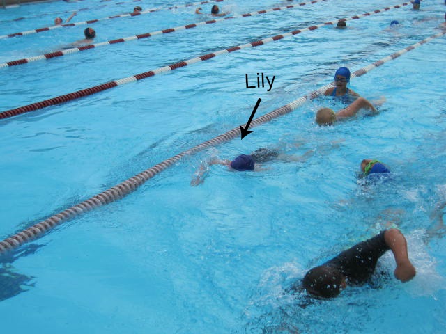 Lily swimming with her team during warm-ups.